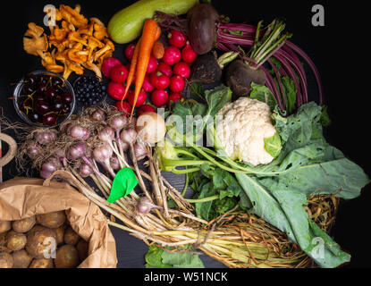 Nahaufnahme des frisch geernteten Gemüse, Rüben, rote Beete, Karotten, Knoblauch, Blumenkohl, Radieschen, Kartoffeln, Pfifferlingen und Berry Kirsche, Heidelbeere Stockfoto