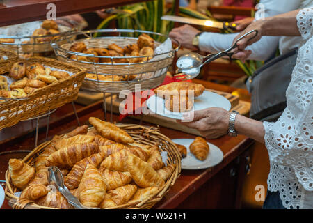 Frau mit puffy Croissants zum Frühstück im luxuriösen Restaurant Stockfoto