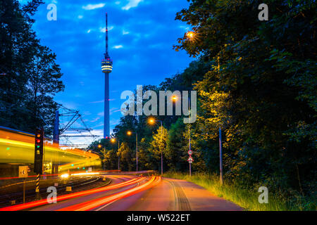 Deutschland, Lichter von beleuchteten Bahn und Verkehr, der von der Straße weg zum Fernsehturm Stuttgart Stadt innerhalb der grünen Wald Natur Landschaft in Stockfoto