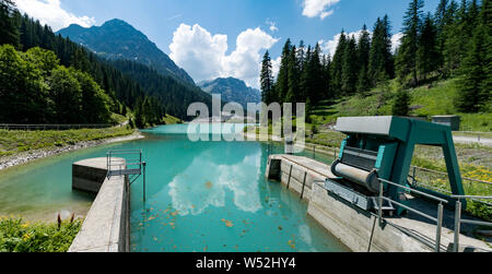 Schlösser und Wehr von einem Damm auf einem türkisfarbenen Bergsee Wasserbehälter in den Schweizer Alpen Stockfoto