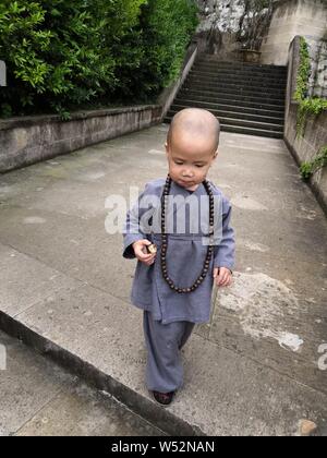 3-jährige Chinese Chen Zhaoyu gekleidet wie ein kleiner Mönch Spaziergänge auf dem Weg zu einem Tempel in Wenling Stadt, der ostchinesischen Provinz Zhejiang, 17. Oktober Stockfoto