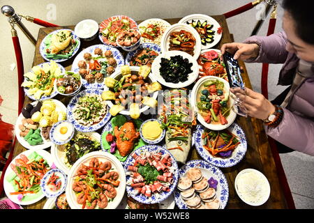 Besucher sehen das Frühlingsfest Gerichte der polymer clay während einer Ausstellung an Laishaoqi Galerie in der Stadt Hefei, Provinz Anhui, China 25. Stockfoto