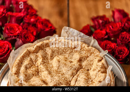 Portugiesische traditionelle Kuchen, Biskuitteig. Auf dem Holztisch mit Rosen. Stockfoto