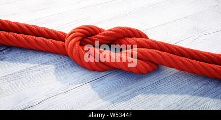 Red Reef knot oder quadratischen Knoten auf dunklem Holz - 3D-Darstellung Stockfoto