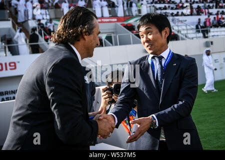 Head Coach Juan Antonio Pizzi von Saudi-arabien, Links, und Haupttrainer Hajime Moriyasu von Japan schütteln sich die Hände, bevor der Umlauf von 16 Match zwischen Japan ein Stockfoto