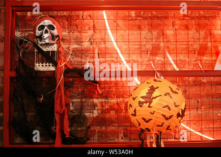 Kürbis Licht mit fliegende Hexe und Fledermäuse, und unheimlichen Schädel Pirat auf neon Wand in der Stadt, Urlaub Dekoration. Halloween Straße eingerichtet. Platz für Te Stockfoto