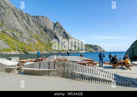 Touristen genießen die Küste Blick vom Fischerdorf Nusfjord, auf der Insel Flakstadøya, in der Lofoten Inseln, Nordland, Norwegen. Stockfoto