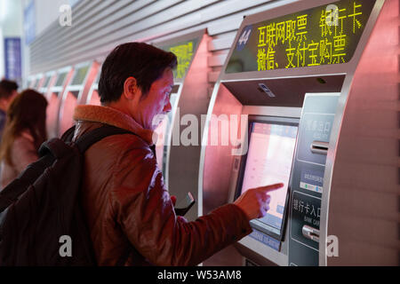 ---- Einen chinesischen Pkw kauft seinen Zug Tickets für das Spring Festival reisen Rush, auch als 'Chunyun', am Bahnhof in Nanjing Nan bekannt Stockfoto