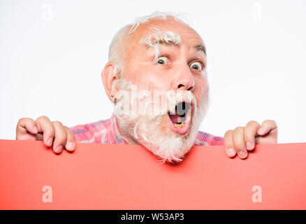 Federn Wahnsinn. Man bärtige Reife emotionale Gesicht mit weißen Federn. Lustige Rentner verrückt. Werbung Konzept. Kissen Partei. Weiche Federn auf seine Wangen. Gesichtsbehaarung. Stockfoto