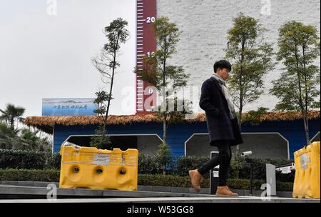 Fußgänger Spaziergang, vorbei an einem riesigen Thermometer mit Anzeige der aktuellen Außentemperatur in Chongqing, China, 4. Januar 2019. Stockfoto