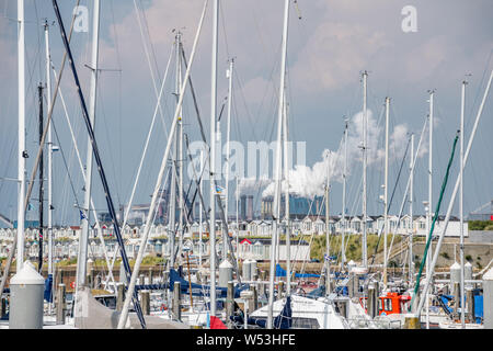 Von Tata Steel IJmuiden arbeitet, ist an der Nordseeküste der Niederlande mit einem Yachthafen im Vordergrund. Stockfoto