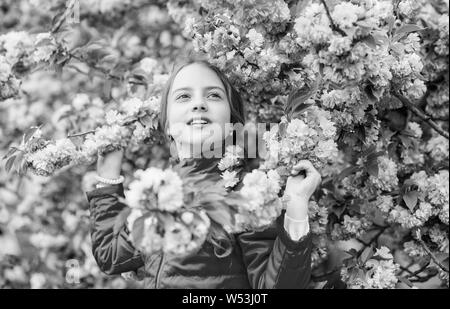 Kid genießen Pink Cherry Blossom. Zarte Blüte. Pink ist die mädchenhafte Farbe. Hell und lebendig. Rosa ist mein Favorit. Kleines Mädchen genießen Sie Frühling. Zicklein auf rosa Blüten von Kirschbaum Hintergrund. Stockfoto