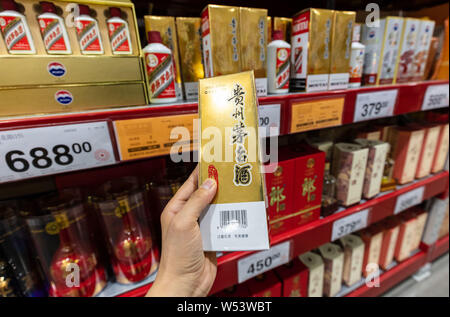 --FILE - ein chinesischer Kunde Geschäfte für eine Flasche Kweichow Moutai liquor in einem Supermarkt in Shanghai, China, 2. September 2018. Kweichow Moutai, ein fi Stockfoto