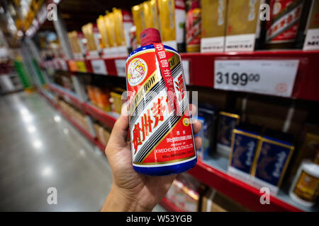 --FILE - ein chinesischer Kunde Geschäfte für eine Flasche Kweichow Moutai liquor in einem Supermarkt in Shanghai, China, 2. September 2018. Kweichow Moutai, ein fi Stockfoto