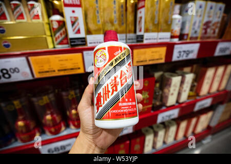 --FILE - ein chinesischer Kunde Geschäfte für eine Flasche Kweichow Moutai liquor in einem Supermarkt in Shanghai, China, 2. September 2018. Kweichow Moutai, ein fi Stockfoto