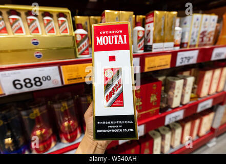 --FILE - ein chinesischer Kunde Geschäfte für eine Flasche Kweichow Moutai liquor in einem Supermarkt in Shanghai, China, 2. September 2018. Kweichow Moutai, ein fi Stockfoto