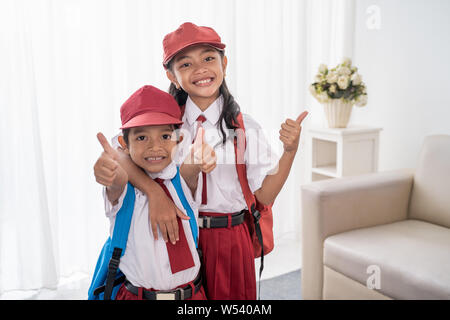 Primäre Schüler tragen Schuluniform, Daumen hoch Stockfoto