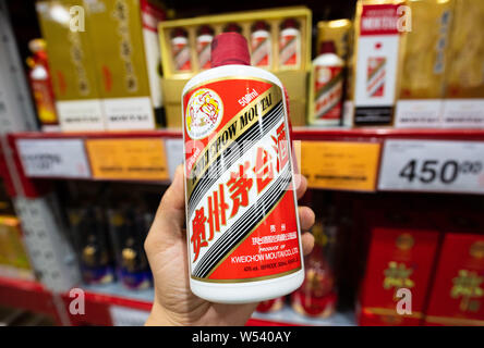 --FILE - ein chinesischer Kunde Geschäfte für eine Flasche Kweichow Moutai liquor in einem Supermarkt in Shanghai, China, 2. September 2018. Kweichow Moutai, ein fi Stockfoto