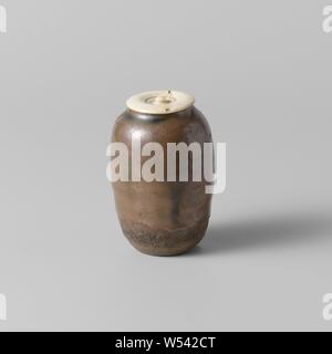 Tee Caddy mit einem goldenbrown Glasur, Staub Tee kann oder Steinzeug chaire mit Elfenbein Deckel, teilweise überdacht mit einer Goldenen braun Glasur. Die untere Hälfte der Bus ist Unglasiert. Wiederherstellung auf dem Hals. Alte Aufkleber auf der Unterseite mit 'W614'. Seto Imonoko., anonym, Japan, C. 1600 - C. 1800, Steinzeug, Glasur, deksel, Verglasung, h 7,9 cm h 7,6 cm, d 3,3 cm, d 5,3 cm, d 3,1 cm h 0,4 cm x T 3,6 cm Stockfoto