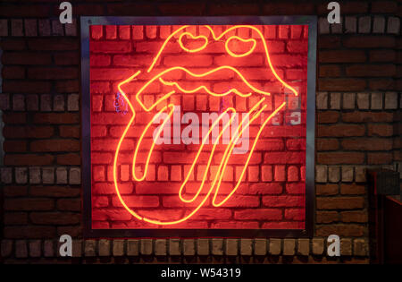 Rock Lippen mit herausgestreckter Zunge mit Neonlicht Stockfoto