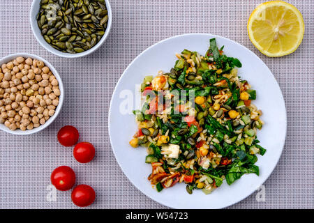 Gesunde, mediterrane Orzo Pasta Salat mit Feta Käse, Kichererbsen und Spinat Stockfoto