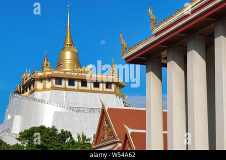 Wat Saket & Der goldene Berg (Phukhao Thong), eine Sehenswürdigkeit Tempel in Bangkok, Thailand, am frühen Morgen mit dem Mond noch über den goldenen Stupa sichtbar Stockfoto