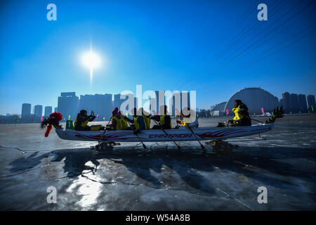 Die anwohner nehmen Sie Teil in einem Ice Dragon Boat Race auf dem gefrorenen Fluss Hunhe in Shenyang City, im Nordosten der chinesischen Provinz Liaoning, 26. Januar 2019. Stockfoto