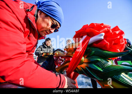 Die anwohner nehmen Sie Teil in einem Ice Dragon Boat Race auf dem gefrorenen Fluss Hunhe in Shenyang City, im Nordosten der chinesischen Provinz Liaoning, 26. Januar 2019. Stockfoto