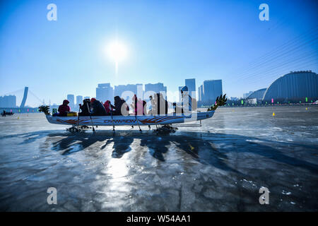Die anwohner nehmen Sie Teil in einem Ice Dragon Boat Race auf dem gefrorenen Fluss Hunhe in Shenyang City, im Nordosten der chinesischen Provinz Liaoning, 26. Januar 2019. Stockfoto