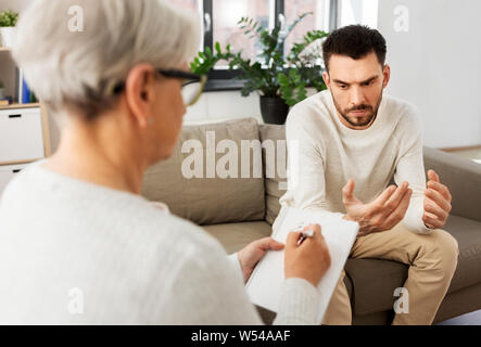 Ältere Frau, die Psychologin und traurigen Mann Patient Stockfoto