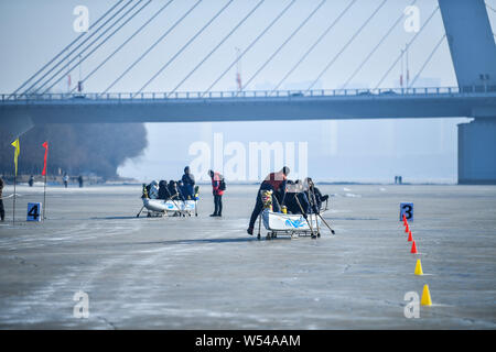Die anwohner nehmen Sie Teil in einem Ice Dragon Boat Race auf dem gefrorenen Fluss Hunhe in Shenyang City, im Nordosten der chinesischen Provinz Liaoning, 26. Januar 2019. Stockfoto