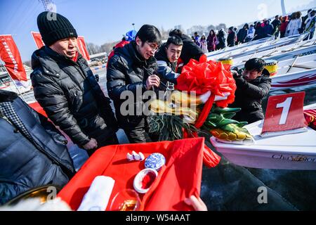 Die anwohner nehmen Sie Teil in einem Ice Dragon Boat Race auf dem gefrorenen Fluss Hunhe in Shenyang City, im Nordosten der chinesischen Provinz Liaoning, 26. Januar 2019. Stockfoto