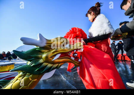 Die anwohner nehmen Sie Teil in einem Ice Dragon Boat Race auf dem gefrorenen Fluss Hunhe in Shenyang City, im Nordosten der chinesischen Provinz Liaoning, 26. Januar 2019. Stockfoto