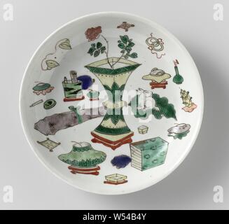 Untertasse - Teller mit wertvollen Objekten und Altertümern, Teller mit runden Wand aus Porzellan, in unterglasur Blau und auf der Glasur Blau, Rot, Grün, Gelb, Aubergine, Schwarz und Gold bemalt. Auf der flachen chinesische Antiquitäten, unten mit vier Wertsachen. Auf der Unterseite mit einer Dichtung in einem doppelten Kreis markiert. Drei Risse in der Kante. Famille Verte., anonym, China, C. 1700 - C. 1724, Qing- Dynastie (1644-1912)/Kangxi-Periode (1662-1722)/Yongzheng-Periode (1723-1735), Porzellan (Material), Glasur, Cobalt (Mineral), Gold (Metall), Verglasung, h 3,1 cm, d 15,9 cm, d 9,2 cm Stockfoto