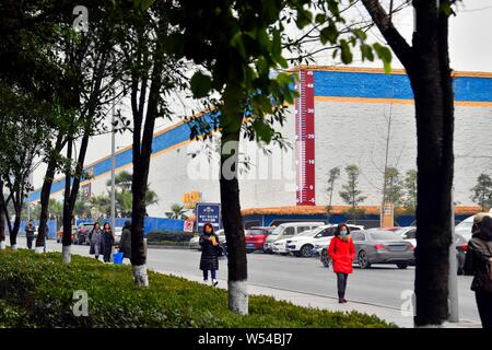 Fußgänger Spaziergang, vorbei an einem riesigen Thermometer mit Anzeige der aktuellen Außentemperatur in Chongqing, China, 4. Januar 2019. Stockfoto