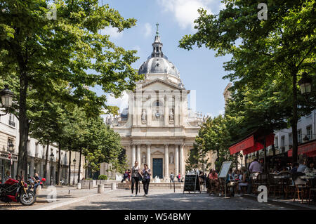 Horizontale Ansicht der Fassade der Universität Sorbonne mit Bäumen und Restaurants umgeben. Touristen zu Fuß in der Nähe Stockfoto