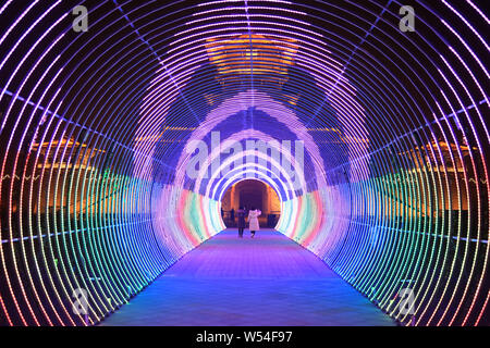 Besucher durch einen Tunnel durch die bunten Lichter, die "Time Tunnel Licht leuchtet der Spaziergang in die Stadt Xiangyang, der Central China Hubei prov Stockfoto