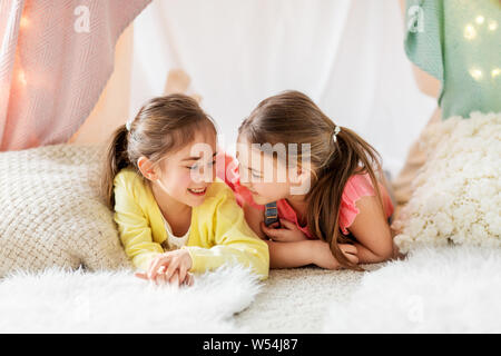 Glückliche Mädchen in Kinder Zelt liegen und sprechen zu Hause Stockfoto