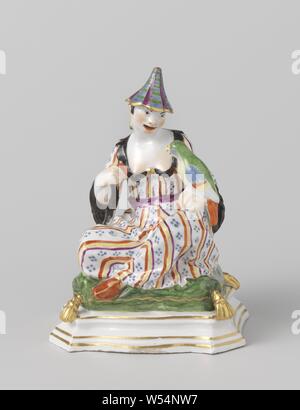 Zwei sitzende Figuren (Pagoden) Sitzende Figur Pagode, Abbildung von bemalten Porzellan. Die Abbildung stellt eine sitzende chinesische Frau (Pagode). Die Frau sitzt im Schneidersitz auf einem grünen Kissen, das auf einem rechteckigen Sockel mit abgeschrägten Ecken liegt. Die Frau hat einen Papagei auf der linken Hand und eine rote Frucht in der rechten Hand. Sie trägt ein spitzen Hut und Ohrringe. Das Bild ist markiert, mit überkreuzten Beinen, wie Schneider bei der Arbeit - AA - weibliche menschliche Figur, Ziervögel: Papagei, Meissener Porzellan Manufaktur, Meißen, 1735, Porzellan (Material), H 16,0 cm x L 12,0 cm × w 9,4 cm Stockfoto