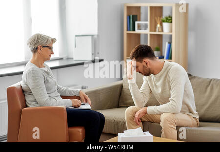 Ältere Frau, die Psychologin und traurigen Mann Patient Stockfoto