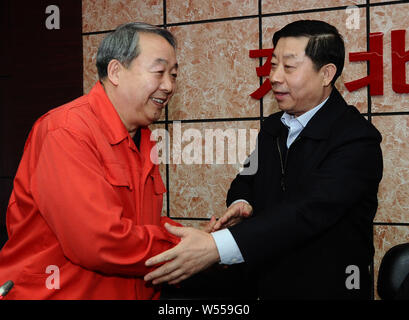 ---- Zhao Mingyuan, Links, dann Präsident der Dongbei Special Steel Group Co., schüttelt Hände mit Yang Hua, neuer Chef der Dongbei Special Steel G Stockfoto