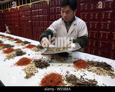 ---- Eine Chinesische pharmaceutist verzichtet der Traditionellen Chinesischen Medizin bei einer Filiale von Peking Tongrentang oder Tong Ren Tang, die Traditionelle Chinesische me Stockfoto