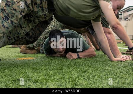 Us Marine GySgt, 26. Juli 2019. Juan Flores, mit Hauptsitz und Sitz Squadron, führt die niedrige kriecht während ein Geschwader körperliches Training Veranstaltung im Marine Corps Air Station Iwakuni, Japan, 26. Juli 2019. HandHS unterstützt Mieter Befehle an WAB Iwakuni durch die Flugsicherung, Flugzeuge Rettung und Brandbekämpfung und Kraftstoffe zusammen mit vielen anderen Funktionen. Regulären Einheit körperliches Training Veranstaltungen wie diese helfen Bereitschaft, Moral und Zusammenhalt zu bewahren. (U.S. Marine Corps Foto von Lance Cpl. Lauren Brune). () Stockfoto