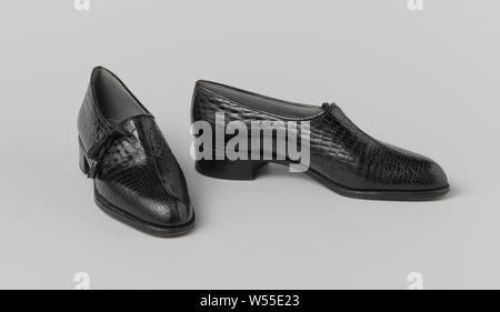 Paar Schnürschuhe Schuhe Slip-on Schuh aus schwarzem Krokodilleder mit asymmetrischer Schnürung, Links instapper von Krokoleder schwarz mit asymmetrischer Schnürung. Modell: eine gerade Naht nach unten läuft der Vorderfuß über den Vorfuß. Split an der Außenseite der vorderen Abdeckung. Niedrig, gerade an der Ferse. Komplett mit grauem Leder gefüttert. Innensohle mit goldenen Drucken. Dekoration: die Spaltung in der rechten Hälfte der Abdeckung ist mit einem schwarzen Stoff Spitze mit Krokoleder schwarz Quasten geschlossen. Adresse (auf der Innensohle): A. VAN GOETHEM 15 RUE DE NAUMUR/PRES LA PLACE ROYALE BRUXELLES. Hinweis: 127592/4633 in Links geschrieben Stockfoto