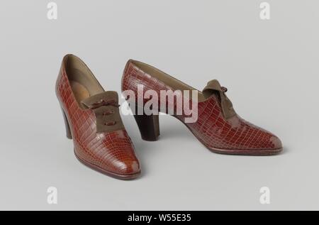 Schuh aus rot-braun snakeskin mit braunem Wildleder Zunge mit einer geschnürt und vernäht Leder Schnüren, den rechten Schuh einer rot-braunen snakeskin mit braunem Wildleder Zunge mit einer geschnürt und vernäht Leder Schnüren. Modell: Der slip-on mit hohem, geradem Absatz (7 cm). Gummizug am Rist für leichten Einstieg. Mit Leber Leder ausgekleidet. Innensohle aus Leder mit goldenen Drucken. Leder Sohle und Absatz. Dekoration: Tarnung, die elastischen Band, eine Zunge des doppelten Nähten Wildleder ist über dem Rist, die aus einer 5 cm großen halbrunden Schnitt im vorderen Blech kommt und verschwindet in angewendet Stockfoto