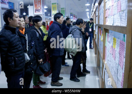 Arbeitsuchende Blick auf die Beschäftigung Informationen auf einen Arbeitsmarkt in Hangzhou City, East China Zhejiang provinz, 20. Februar 2019. Druck nach unten Stockfoto