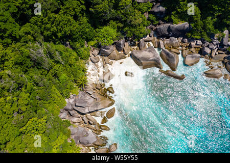 Luftaufnahme von einer kleinen Bucht auf einer wunderschönen tropischen Insel mit Korallenriff und Granitfelsen Stockfoto