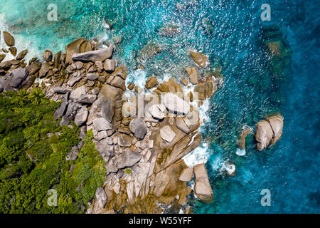 Luftaufnahme von einer kleinen Bucht auf einer wunderschönen tropischen Insel mit Korallenriff und Granitfelsen Stockfoto