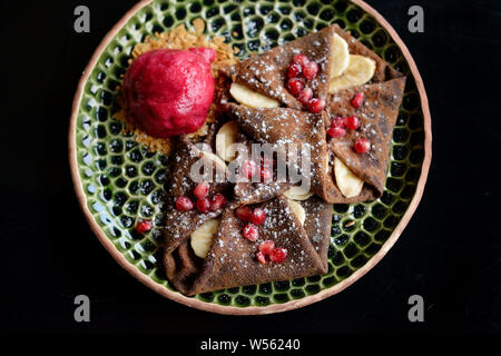 Schokolade Pfannkuchen mit Bananen-, Granatapfel- und Sorbet Stockfoto