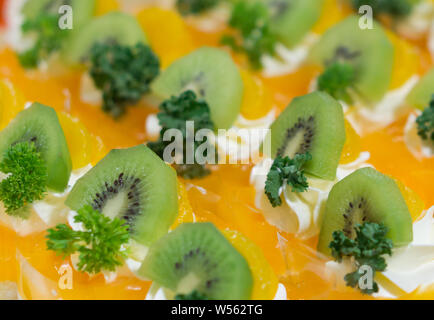 Orange Kuchen mit Kiwi dekoriert. Stockfoto